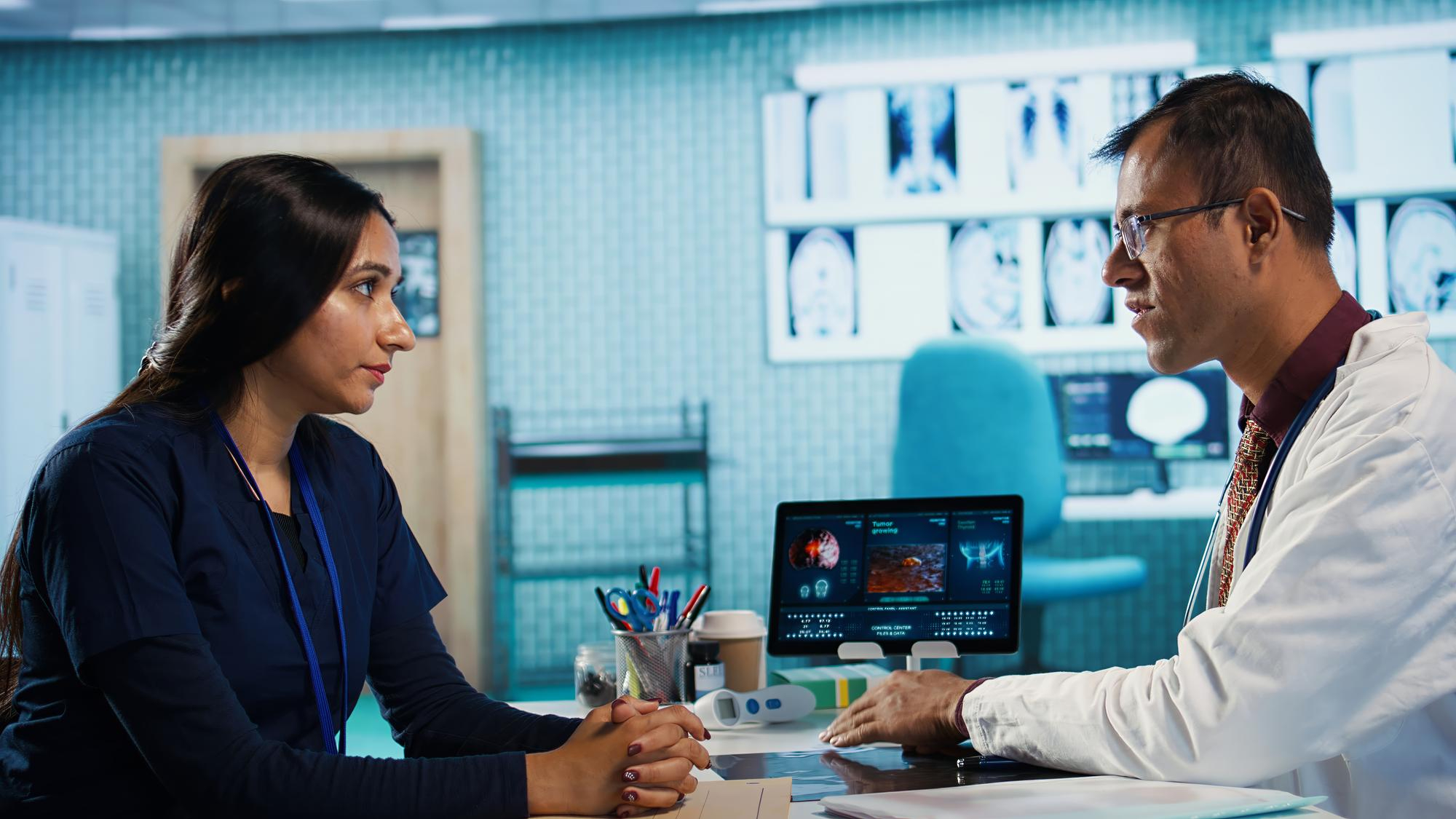 Physician meeting with patient to discuss medical test results in cabinet