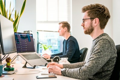 IT specialist working on multiple monitors managing healthcare infrastructure